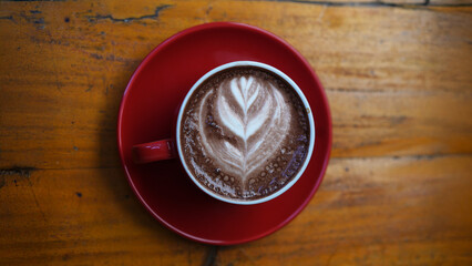 Creamy Latte Art in Red Cup on Minimalist Wooden Table – Coffee Scene in Landscape Orientation