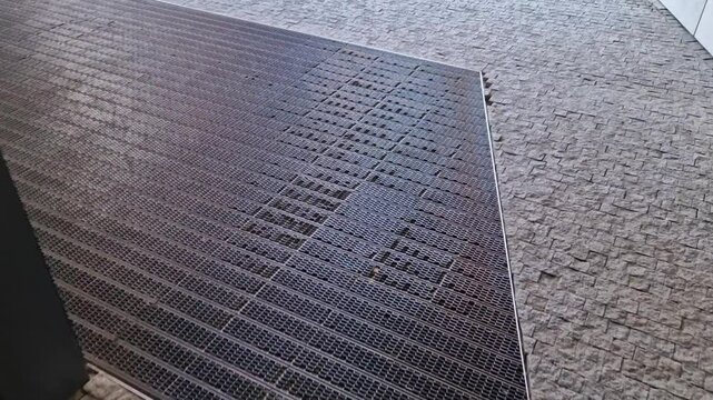 industrial mat cleaning zones at the entrance to the building. A black plastic-metal mat in the shape of an arch or half-circle lies on the limestone mosaic tiles