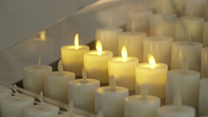 Automatic candles glowing softly indoors in a church creating a peaceful and spiritual atmosphere...