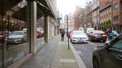 Street scene with blurred pedestrian and vehicles in london winter, capturing the urban atmosphere with reflections and defocused background.