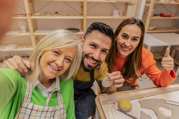 Happy potters taking selfie in pottery workshop