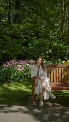 Fototapeta premium Woman sitting on a bench in a tulip garden in lisse, netherlands, surrounded by vibrant flowers and lush greenery, enjoying a sunny day.