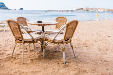 Outdoor cafe or restaurant with sea view and empty chairs. Coastal relaxation, summer tourism, and beachfront dining in the Mediterranean region.