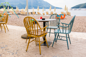 Outdoor cafe or restaurant with sea view and empty chairs. Coastal relaxation, summer tourism, and beachfront dining in the Mediterranean region.
