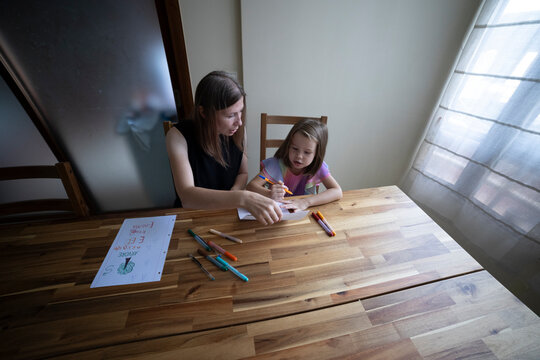 Mother helping daughter with homework, homeschooling during quarantine