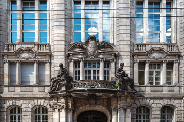 A detailed view of a richly decorated historic building facade in Berlin, Germany, featuring a prominent central balcony flanked by classical sculptures.
