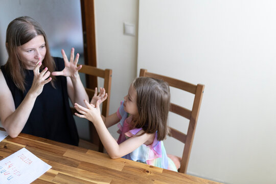 Teacher and student communicating using sign language at home