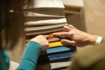 A couple actively discusses and points to fabric samples, demonstrating collaboration and creativity for home decor.