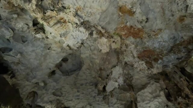 Amazing stalagmites and textured limestone formations inside Thien Cung Cave, Ha Long Bay, Vietnam. Panning footage.