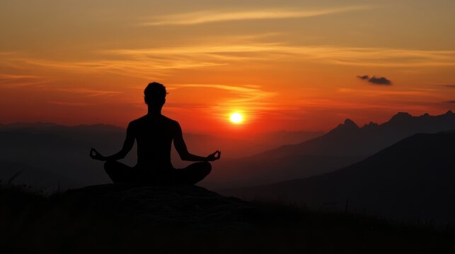 Silhouette of a person meditating in lotus pose against a vibrant sunset backdrop with mountain silhouettes