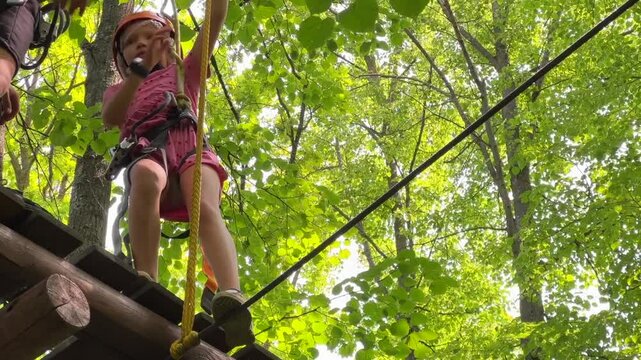 a child walks along an obstacle course in a rope park