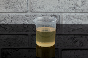 Food Additive E433 or Polysorbate 80 in plastic measuring cup. Polyoxyethylene (20) sorbitan...