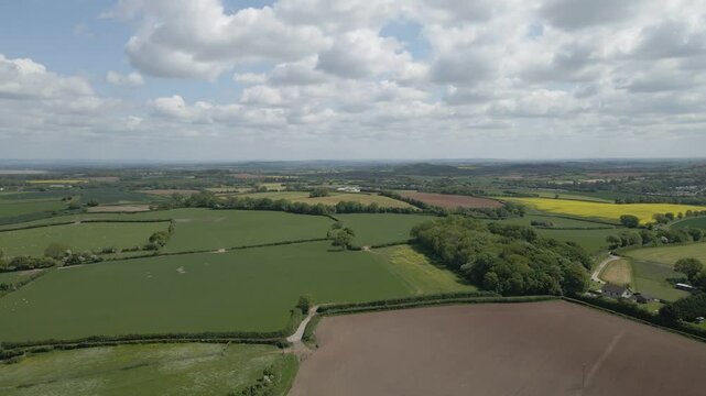 Arial view of Stogursey parish in the quantock hills Somerset. Drone rotating to the left showing the green fields and the quantocks on the background