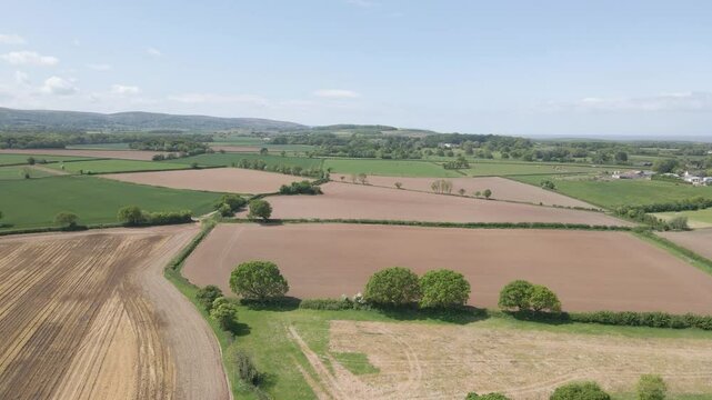 Arial view of Stogursey parish in the quantock hills Somerset. Drone slowly moving forward over the green fields and showing the quantocks on the background.