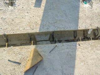 Concrete slab under construction showing steel reinforcement and a wooden wedge piece.