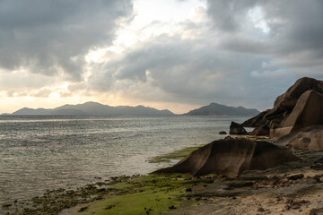 Granite rocks and sandy shoreline meet ocean waves on La Digue, Seychelles