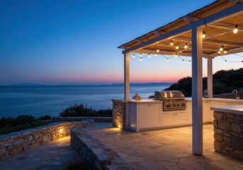 Outdoor kitchen with grill and ocean view at dusk, illuminated by string lights