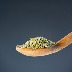 Heap of fennel spice seeds on rustic wooden utensil, great for healthy cooking and ingredient themes