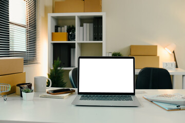 Online seller workspace with laptop, shipping boxes, and office supplies. E-commerce concept