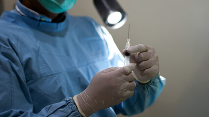 Closeup of Doctor Hand Holding Syringe Ready for Injection