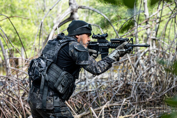 Naklejka premium military men in combat gear patrol in the middle of tropical jungle.