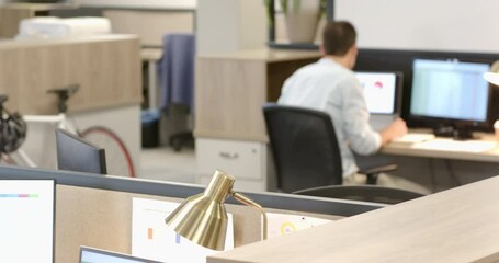 Diverse coworkers sorting printed charts then walking through office to compare graphs on monitors