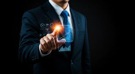 A businessman in a suit touching a holographic screen displaying data and charts on a black background