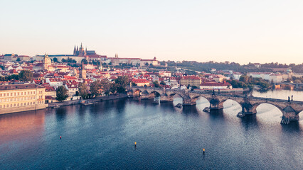 As dawn breaks over Prague, the golden hues illuminate the medieval architecture along the Vltava...