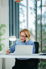 Middle aged asian woman working on documents data at contemporary office