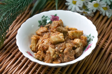 A bowl of Sambal Goreng Pengantin, a rich, traditional Malay dish made from a combination of beef liver, lung, trimmings, spleen, prawns, tofu, and tempe in coconut gravy, perfect for festive meals.
