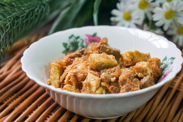 A bowl of Sambal Goreng Pengantin, a rich, traditional Malay dish made from a combination of beef liver, lung, trimmings, spleen, prawns, tofu, and tempe in coconut gravy, perfect for festive meals.

