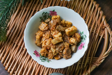 A bowl of Sambal Goreng Pengantin, a rich, traditional Malay dish made from a combination of beef liver, lung, trimmings, spleen, prawns, tofu, and tempe in coconut gravy, perfect for festive meals.
