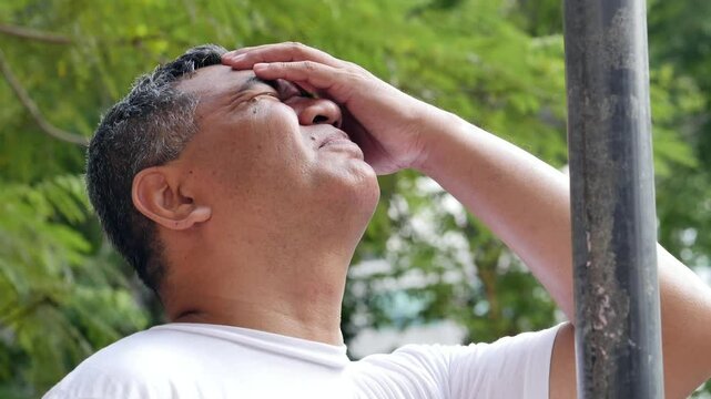 unlucky careless old senior man hitting his head with iron pole, concept of bad day, unlucky happenings, head injury, head accident, brain injury, real southeast asian senior man model