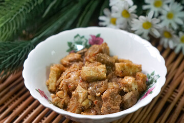 A bowl of Sambal Goreng Pengantin, a rich, traditional Malay dish made from a combination of beef liver, lung, trimmings, spleen, prawns, tofu, and tempe in coconut gravy, perfect for festive meals.
