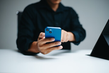 Man using smartphone and stylus at clean tech desk. Modern business communication, digital interface, touchscreen tech, and mobile