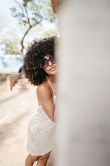 Portrait of a woman with afro hair and sunglasses smiling and happy - Modern fashion and style concept.