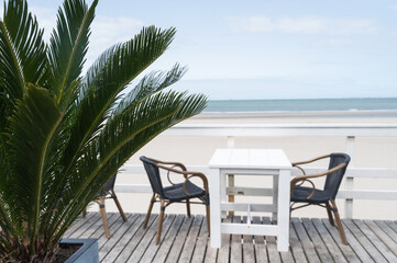A lovely table and chairs on a deck overlook the vast ocean
