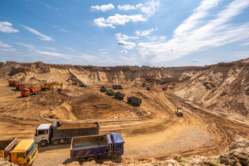 From afar - the work of a sand quarry. There is a lot of equipment, the development of minerals is underway.