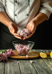Chef adds acacia flowers to a bowl to make delicious kvass. Concept of making healthy lemon drink at home in the kitchen
