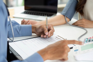 Patient Consultation. Doctor recording health information during medical appointment.