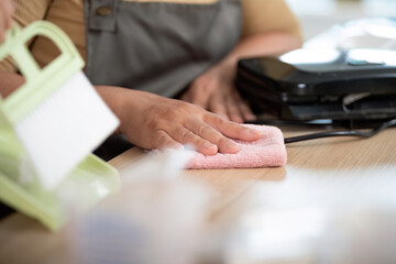 Cleaning and Tidying Up. An adult wipes the kitchen counter while a child assists.