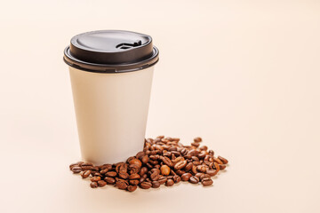 A paper cup of freshly brewed coffee surrounded by rich, aromatic roasted coffee beans