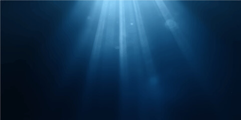 Sunlight rays beam through the deep blue ocean, illuminating a glowing underwater world