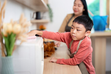 Cleaning Together. A child helping his mother with kitchen cleaning tasks.