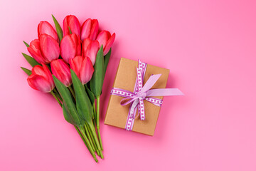 Pink tulip bouquet and gift box on a soft pink background
