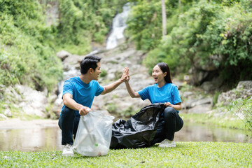 Volunteer Teamwork. Two volunteers celebrating a successful clean-up in nature.