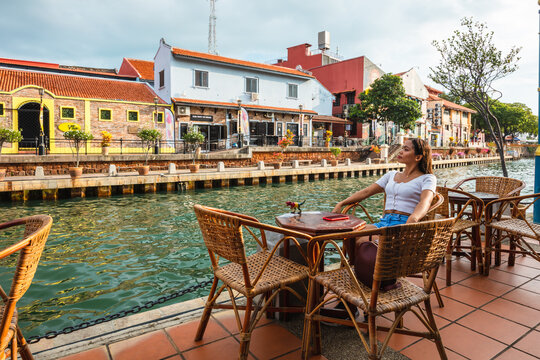 Asian woman sitting in an outdoor cafe near the river, Malacca, Malaysia