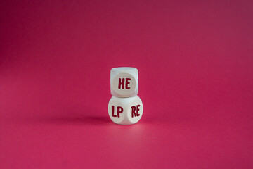 Help here symbol. Wooden cubes with words 'help' and 'here'. Beautiful dark red background.