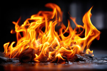 Flames dance above glowing embers in the darkness of night near a cozy campfire