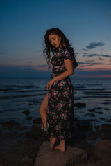 Woman in dress standing near the lake at evening